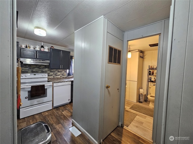 kitchen featuring decorative backsplash, white appliances, and dark wood-type flooring