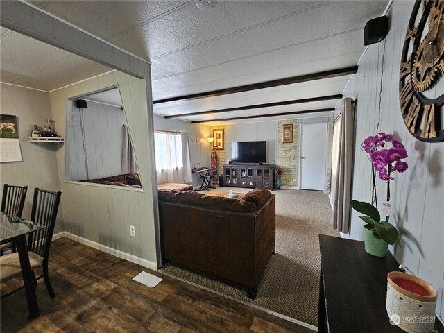 living room with beamed ceiling and dark wood-type flooring