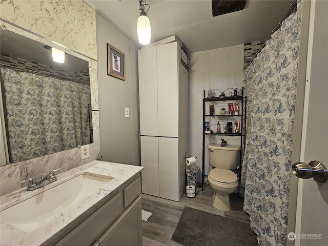 bathroom with toilet, vanity, and hardwood / wood-style flooring