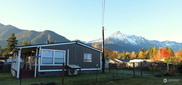 rear view of house with a lawn and a mountain view