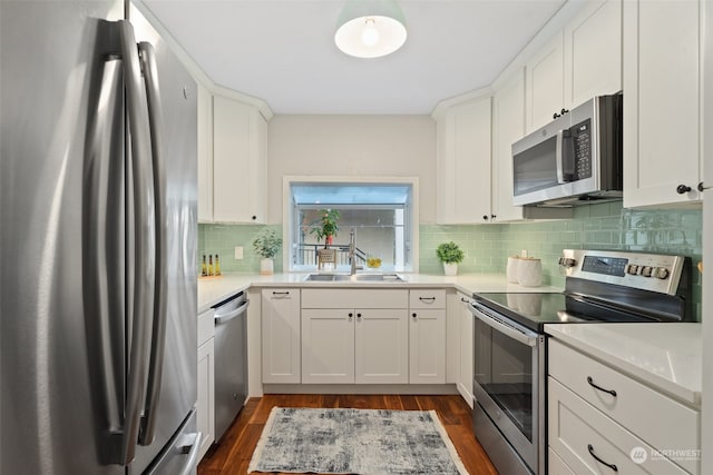 kitchen with dark hardwood / wood-style flooring, white cabinetry, appliances with stainless steel finishes, and sink