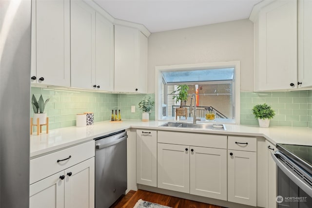 kitchen with stainless steel appliances, dark wood-type flooring, white cabinets, decorative backsplash, and sink