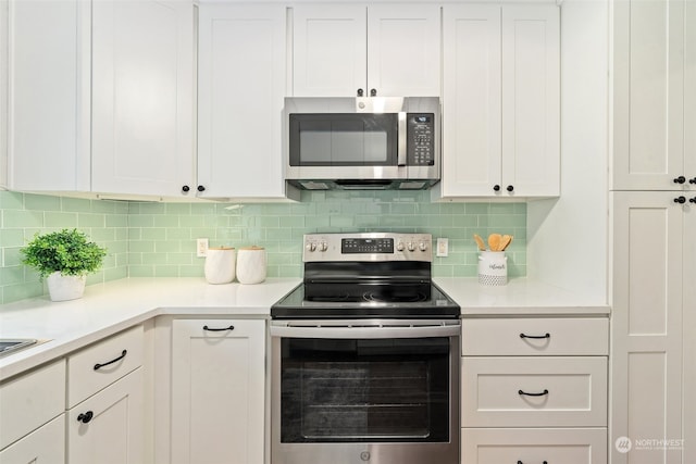 kitchen with white cabinets, decorative backsplash, and appliances with stainless steel finishes