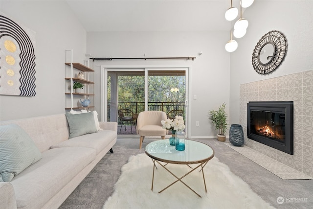 carpeted living room featuring a tiled fireplace