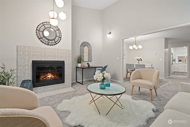 living room featuring light colored carpet, a tile fireplace, and a towering ceiling