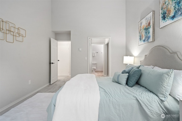 bedroom featuring ensuite bathroom and light colored carpet