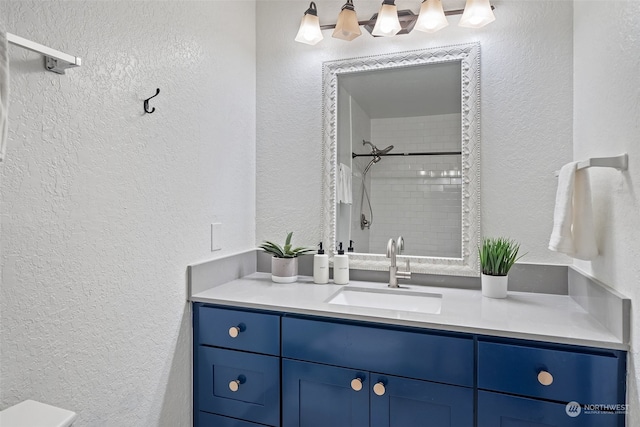 bathroom featuring tiled shower, vanity, and toilet