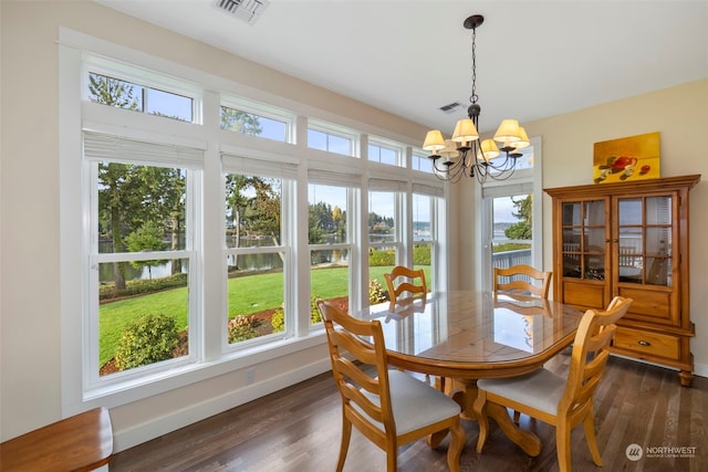 dining room with dark hardwood / wood-style floors, a wealth of natural light, and a notable chandelier