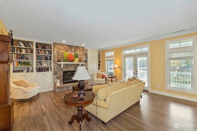 living room featuring crown molding, a fireplace, wood-type flooring, and french doors