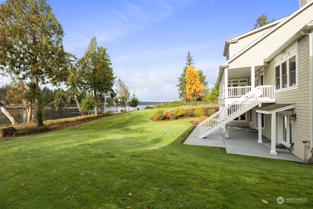 view of yard with a patio and a water view