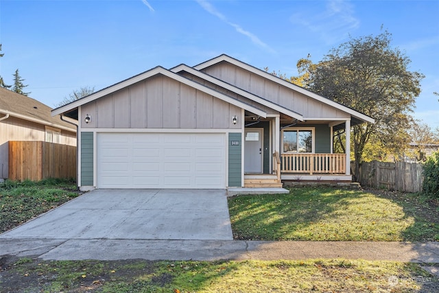 view of front of home featuring a front yard, a garage, and covered porch