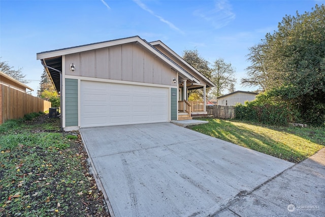 view of front of property with a garage, central air condition unit, and a front lawn