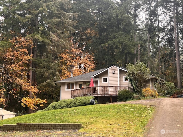 view of front of property featuring a front yard and a wooden deck