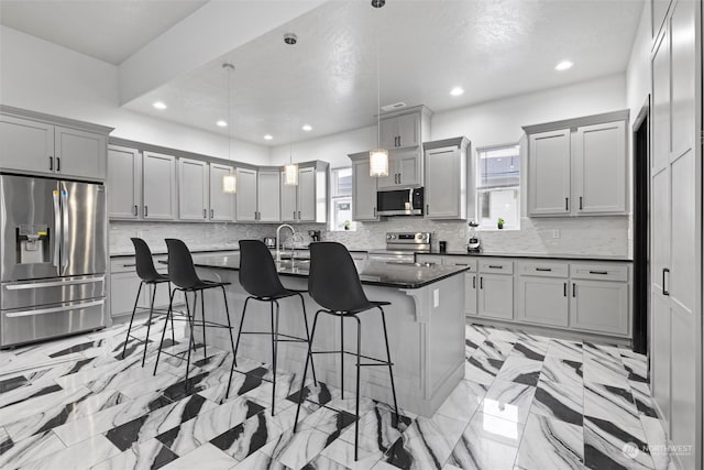 205 Clayton Pl, Mattawa, WA 99349 - kitchen featuring appliances with stainless steel finishes, gray cabinets, plenty of natural light, a breakfast bar area, and recessed lighting