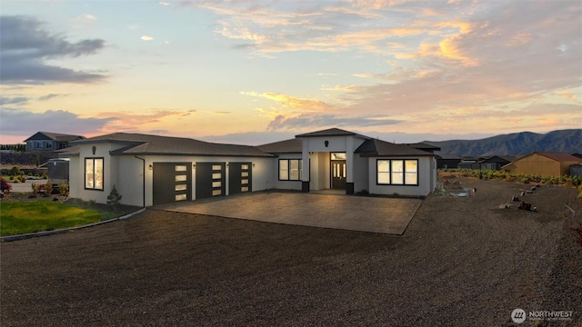 205 Clayton Pl, Mattawa, WA 99349 - view of front of house with driveway, an attached garage, stucco siding, and a mountain view