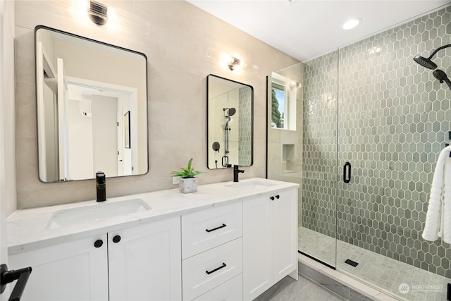 bathroom featuring vanity, an enclosed shower, and tile walls