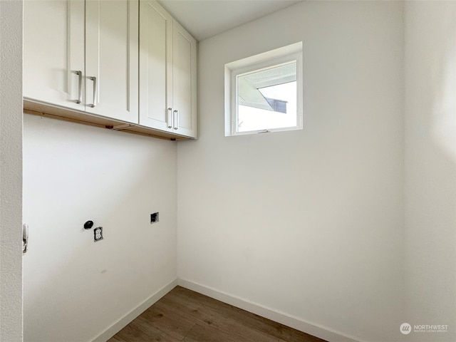 laundry area featuring cabinets, electric dryer hookup, and dark wood-type flooring