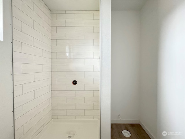 bathroom featuring a tile shower and hardwood / wood-style flooring