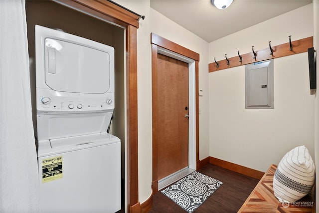 washroom with stacked washing maching and dryer, electric panel, and dark hardwood / wood-style floors