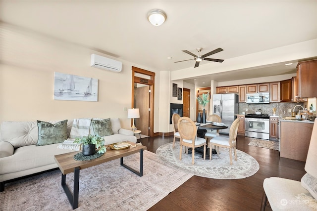 living room featuring ceiling fan, sink, a wall mounted air conditioner, and dark hardwood / wood-style floors