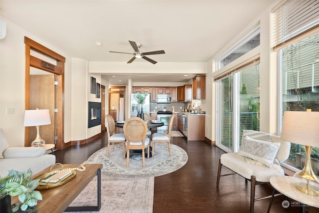 living room with dark wood-type flooring, ceiling fan, and sink