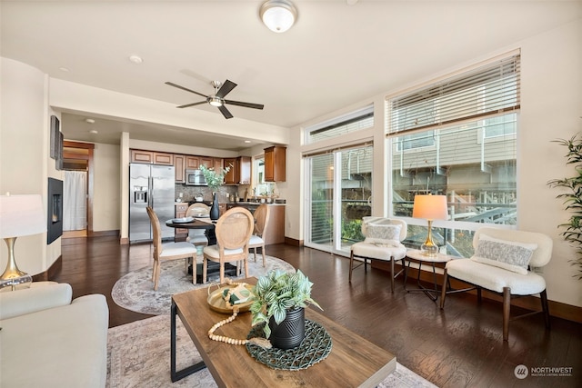 living room featuring dark hardwood / wood-style flooring, ceiling fan, and plenty of natural light