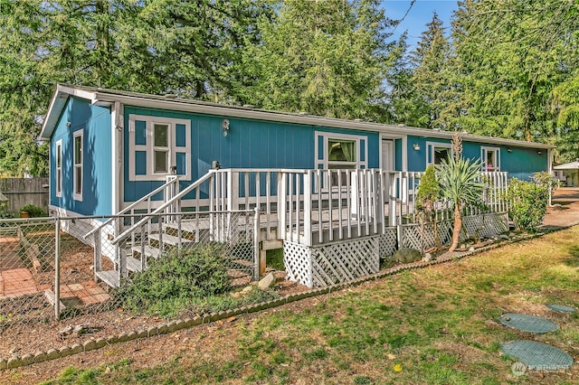 view of front of property featuring a deck and a front yard