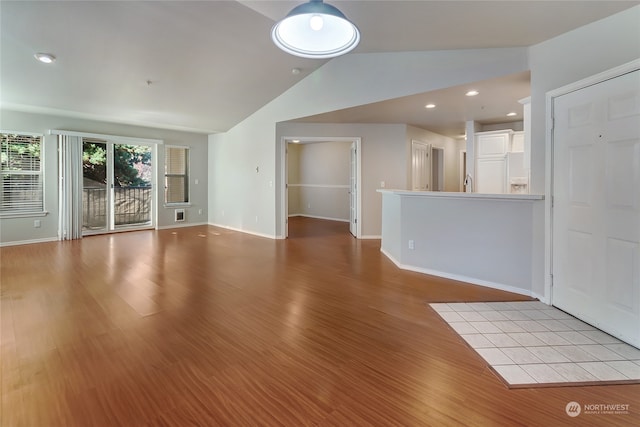 unfurnished living room featuring light wood-type flooring and lofted ceiling