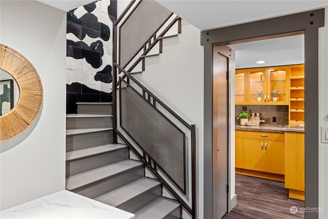 staircase featuring bar area and hardwood / wood-style flooring