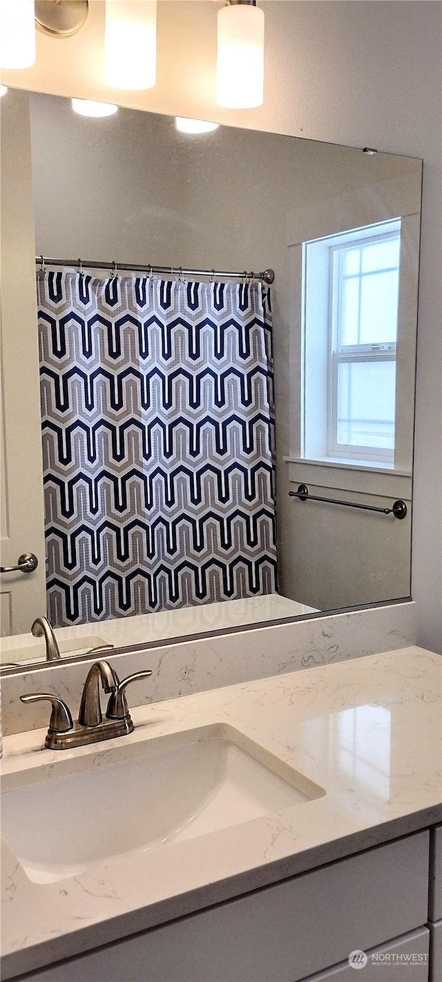 bathroom with walk in shower and vanity