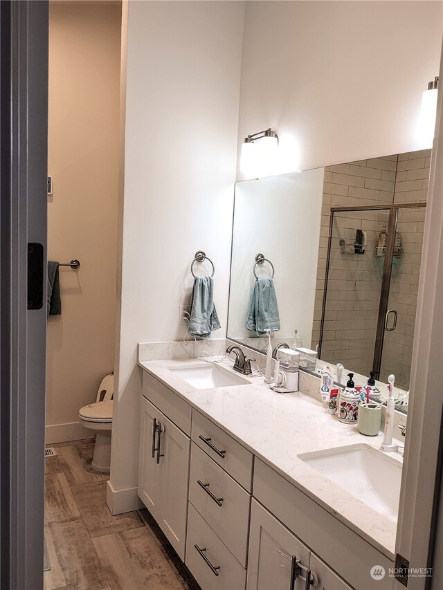 bathroom with walk in shower, vanity, and toilet