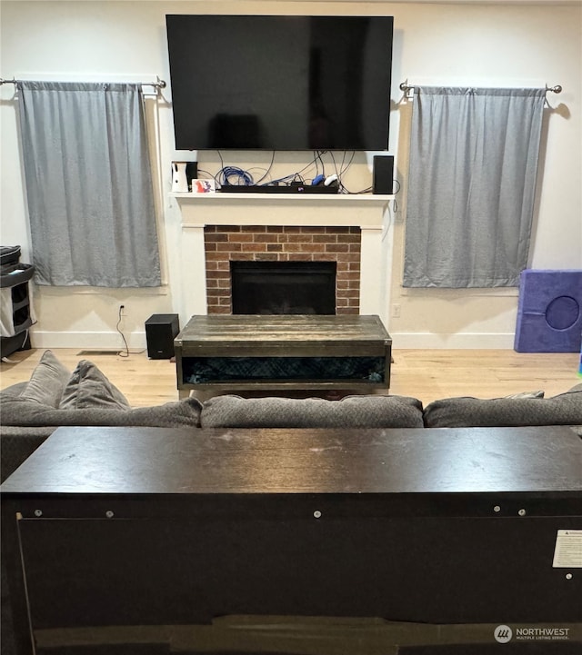 living room featuring hardwood / wood-style floors and a brick fireplace