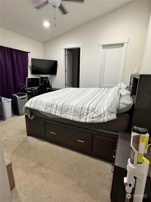 bedroom with vaulted ceiling, light colored carpet, and ceiling fan