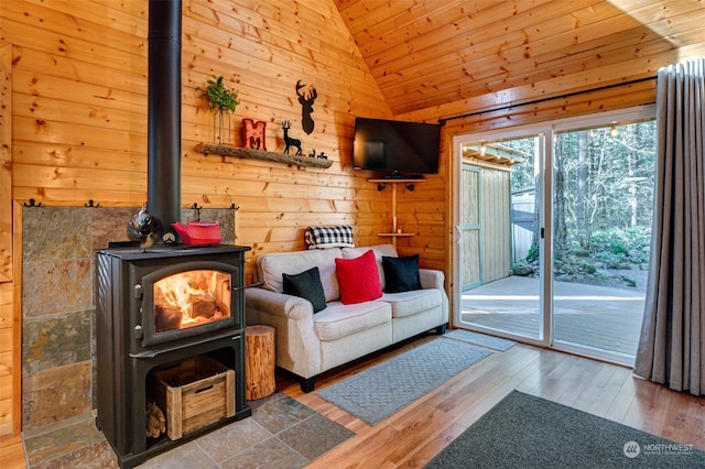 living room featuring a wood stove, lofted ceiling, and hardwood / wood-style flooring