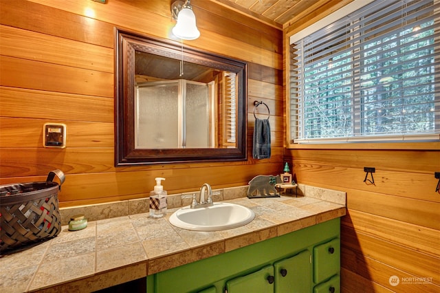 bathroom with vanity, wooden walls, wood ceiling, and a shower with shower door