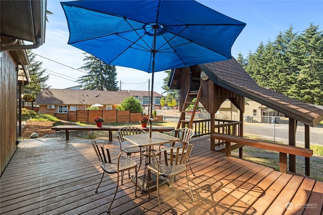 deck featuring outdoor dining area and fence