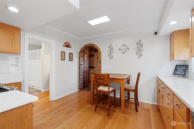 dining area featuring light wood-type flooring, baseboards, arched walkways, and recessed lighting