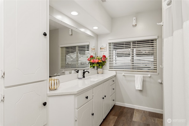 bathroom featuring recessed lighting, vanity, baseboards, and wood finished floors