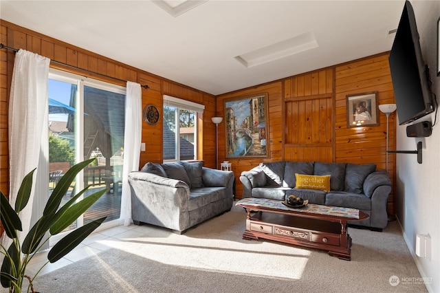 carpeted living room featuring wood walls