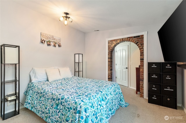 bedroom featuring baseboards, visible vents, arched walkways, and carpet flooring