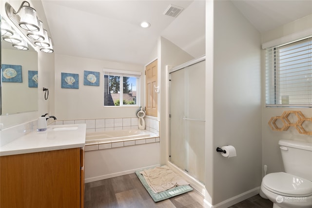 bathroom with visible vents, toilet, a stall shower, wood finished floors, and a bath