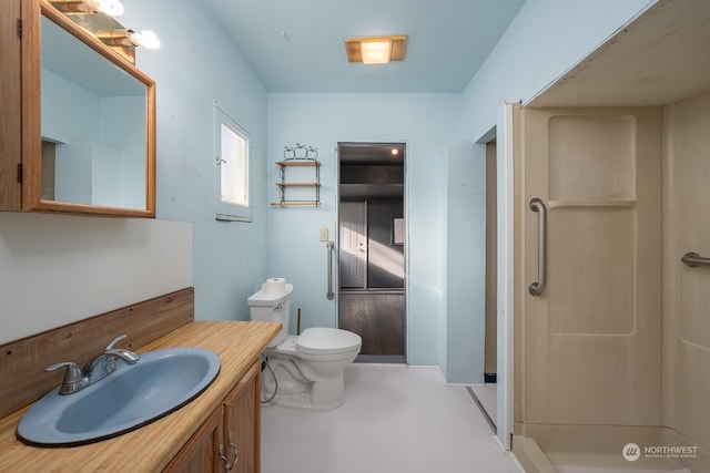 bathroom featuring toilet, a shower, and vanity