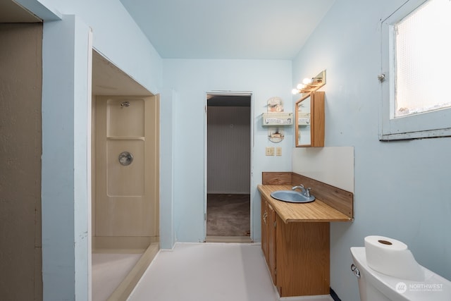 bathroom with walk in shower, vanity, and toilet