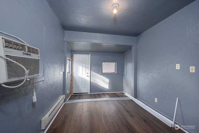 doorway to outside with a baseboard heating unit and dark hardwood / wood-style flooring