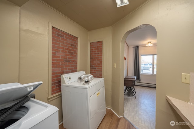 laundry room with washer and dryer, a baseboard radiator, light wood-type flooring, and ornamental molding