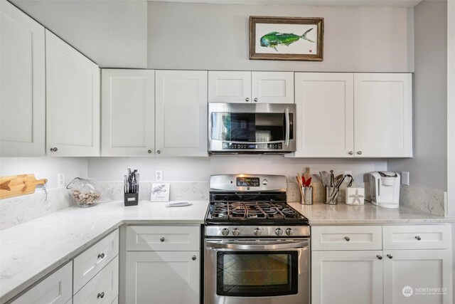 3821 NE 14th Pl, Renton, WA 98056 - kitchen featuring appliances with stainless steel finishes, white cabinets, and light stone counters