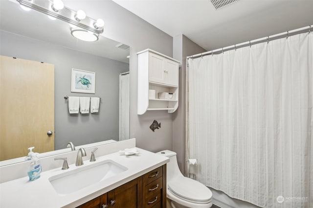 bathroom with curtained shower, vanity, and toilet