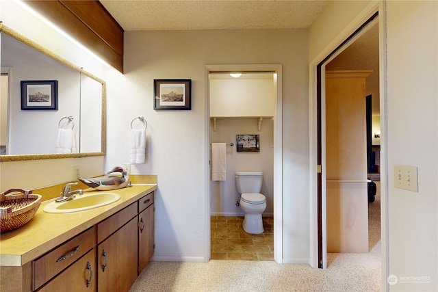 bathroom featuring vanity, toilet, and a textured ceiling