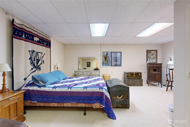 carpeted bedroom featuring a drop ceiling