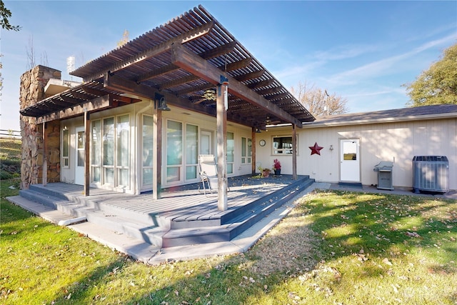 rear view of house with a pergola, cooling unit, and a lawn